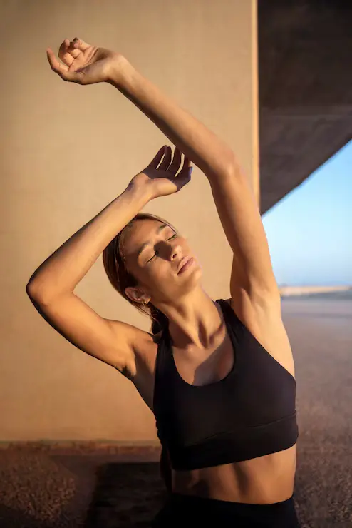 Mujer estirando los brazos al sol